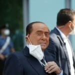 Silvio Berlusconi si dáva dole z tváre ochranné rúško po prepustení z Nemocnice sv. Rafaela.
