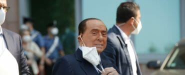 Silvio Berlusconi si dáva dole z tváre ochranné rúško po prepustení z Nemocnice sv. Rafaela.