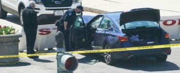 Policajti stoja neďaleko automobilu, ktorý narazil do bariéry pred sídlom vlády USA v Capitol Hill vo Washingtone v piatok 2. apríla 2021.