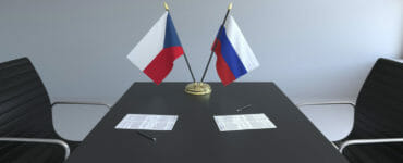 Česká a ruská vlajka na rokovacom stole.
