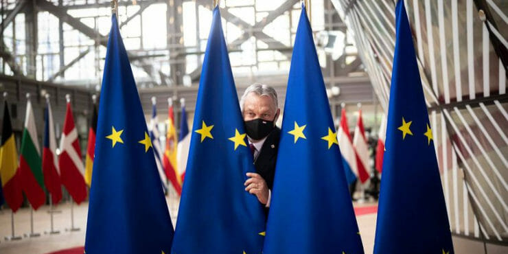 Viktor Orbán v Bruseli medzi vlajkami Únie.