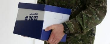 Vojak odnáša petičné hárky za vyhlásenie referenda o predčasných voľbách do Prezidentského paláca v Bratislave v pondelok 3. mája 2021.