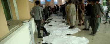 Afganskí muži identifikujú telá obetí po výbuchu bomby.