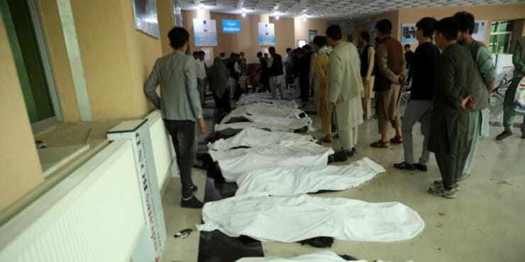 Afganskí muži identifikujú telá obetí po výbuchu bomby.