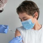 Očkovanie tínedžera vakcínou proti koronavírusu.