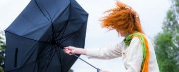 Žena čelí vetru a dažďu.