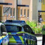 Policajti stoja pred domom v nemeckom meste Espelkamp 17. júna 2021. Najmenej dvaja ľudia, muž a žena, prišli vo štvrtok o život pri streľbe