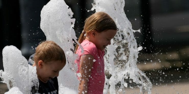 Deti šantia vo fontáne počas horúceho dňa v maďarskej Budapešti 23. júna 2021.
