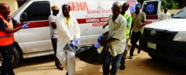 Záchranári odnášajú telo zo sanitky po útoku na trhovisku v obci Konduga.