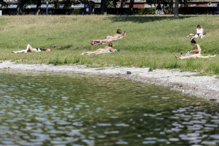 Ľudia sa slnia pri Štrkoveckom jazere počas horúcich letných dní v Bratislave.