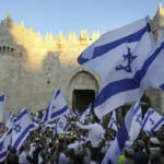 zraelskí nacionalisti mávajú izraelskými vlajkami počas vlajkového pochodu v Jeruzaleme