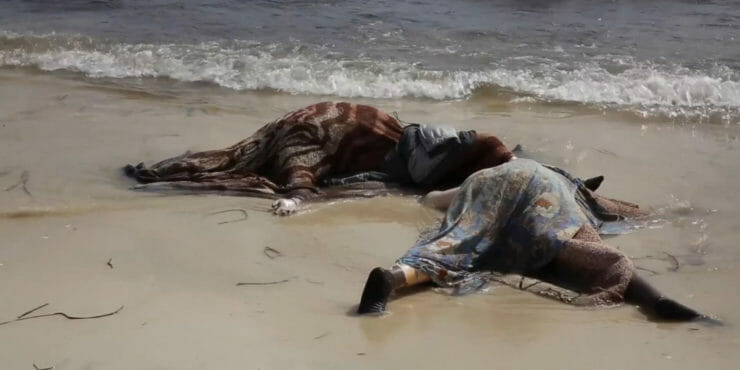 Mŕtve telá utopených afrických migrantov ležia na pláži.