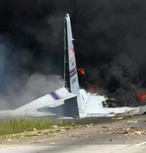 Pohľad na dym a plamene zo spadnutého nákladného lietadla typu C-130.