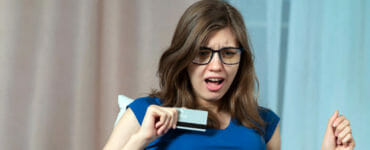Žena za počítačom s bankomatovou kartou.