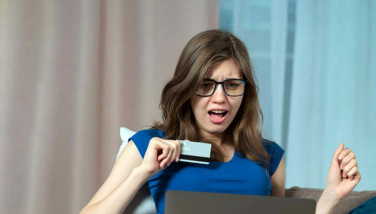 Žena za počítačom s bankomatovou kartou.