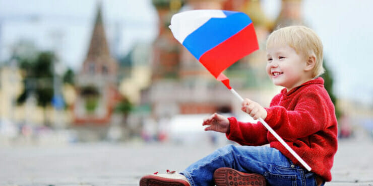 Chlapček s ruskou zástavou na Červenom námestí v Moskve.
