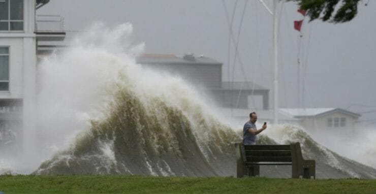 Muž si fotí vysokú vlnu pri probreží počas hurikánu Ida v americkom meste New Orleans v nedeľu 29. augusta 2021.