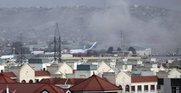 Dym stúpa po explózii na letisku v Kábule 26. augusta 2021.
