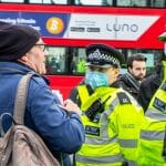Londýnski policajti sa rozprávajú s mužom.