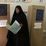 Iracká volička vychádza spoza plenty vo volebnej miestnosti v Bagdade počas parlamentných volieb v Iraku 12. mája 2018.
