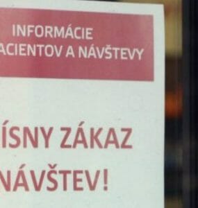 Šaca informuje návštevníkov nemocnice o zákaze návštev vylepeným oznamom pri hlavnom vchode.