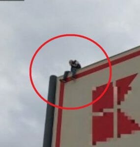 Muž na streche obchodného centra v Malackách.