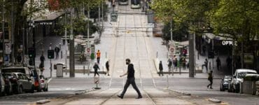 Ľudia kráčajú cez cestu v Melbourne 30. septembra 2021.