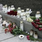 Kvety a sviečky sú položené po stredajšom útoku muža v nórskom meste Kongsberg.