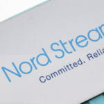 Značka s nápisom Severný prúd 2 (Nord Stream 2) visí nad namaľovanou mapou 16. novembra 2021 v nemeckom Lubmine.