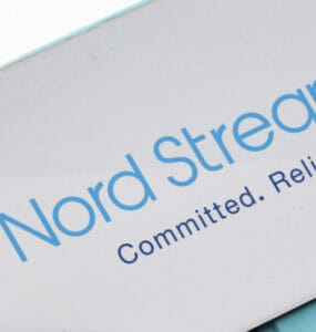 Značka s nápisom Severný prúd 2 (Nord Stream 2) visí nad namaľovanou mapou 16. novembra 2021 v nemeckom Lubmine.