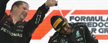 Britský pilot F1 Lewis Hamilton sa teší na pódiu s členom tímu.