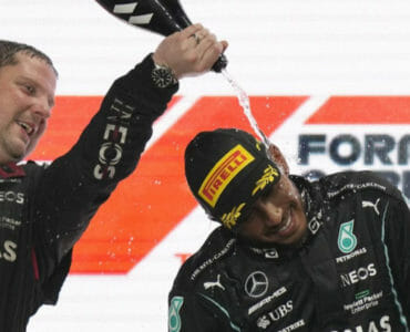Britský pilot F1 Lewis Hamilton sa teší na pódiu s členom tímu.