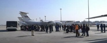 Ľudia čakajú na nástup do ruského vojenského lietadla Il-76 na letisku v Kábule 18. decembra 2021.