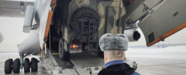 Ruskí príslušníci mierových síl pomáhajú dostať vozidlo do lietadla pred odletom do Kazachstanu 6. januára 2022 na letisku neďaleko Moskvy.