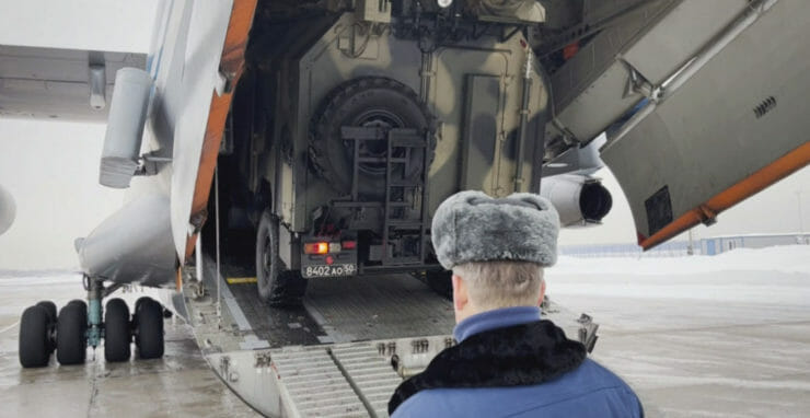 Ruskí príslušníci mierových síl pomáhajú dostať vozidlo do lietadla pred odletom do Kazachstanu 6. januára 2022 na letisku neďaleko Moskvy.