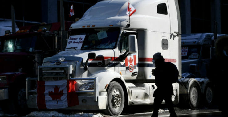 Chodec kráča okolo zaparkovaného kamióna 7. februára 2022 v Ottawe.