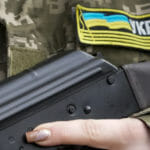 Príslušníčka civilnej obrany so zbraňou hliadkuje na prázdnej ulici kvôli zákazu vychádzania 27. februára 2022 v Kyjeve.