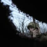 Ukrajinský vojak počúva delostreleckú paľbu v zákopoch na frontovej línii. Ukrajinský vojak počúva delostreleckú paľbu v zákopoch na frontovej línii.