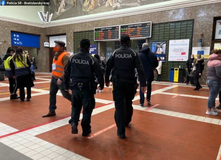 Policajti hliadkujú vo vestibule Hlavnej železničnej stanice v Bratislave.