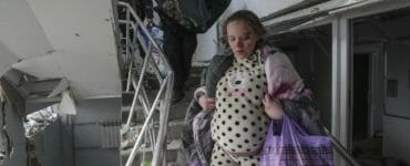 Zranená tehotná žena kráča po schodoch v zničenej budove pôrodnice po ostreľovaní v Mariupole.