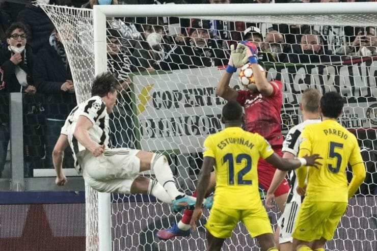 Brankár Villarrealu Geronimo Rulli chytá loptu z kopačky Dušana Vlahoviča z Juventusu.