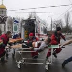 Záchranári privážajú zraneného muža počas ostreľovania obytnej oblasti na ošetrenie do pôrodnice v meste Mariupoľ.