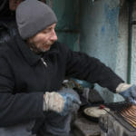 Na ilustračnej snímke pripravuje občan Ukrajiny jedlo v Mariupole, 13. apríla 2022.