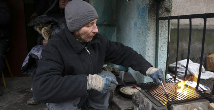 Na ilustračnej snímke pripravuje občan Ukrajiny jedlo v Mariupole, 13. apríla 2022.