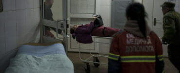 Na ilustračnej snímke záchranári prevážajú do nemocnice ženu ranenú pri ruskom bombardovaní v Charkove v nedeľu 17. apríla 2022.