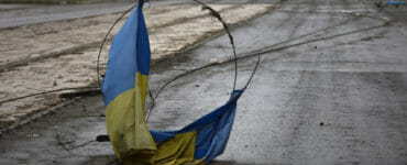 Na ilustračnej snímke ukrajinská vlajka na ceste v meste Mariupol počas 54. dňa ruskej invázie na Ukrajinu v pondelok 18. apríla 2022.
