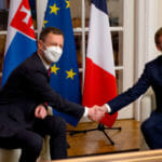 Emmanuel Macron (vpravo) a Eduard Heger (vľavo) si podávajú ruky v decembri 2021.