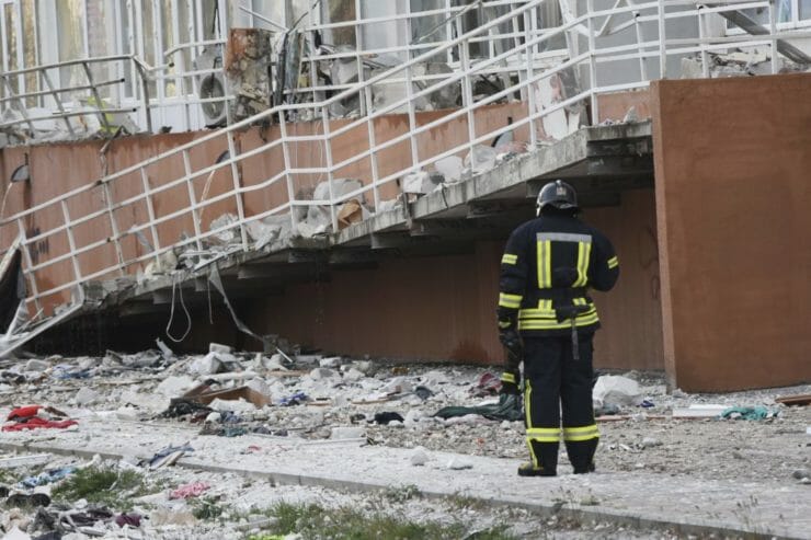 Na snímke hasič stojí vedľa obytného domu poškodeného ruským ostreľovaním v Odese na Ukrajine v sobotu 23. apríla 2022.