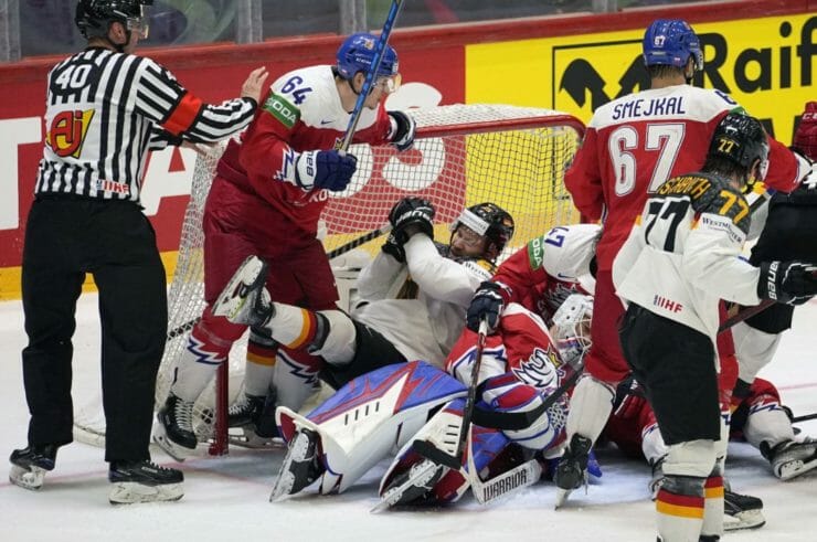 Nemecký hokejista Daniel Schmölz padá do českej brány vo štvrťfinálovom zápase Nemecko - Česko