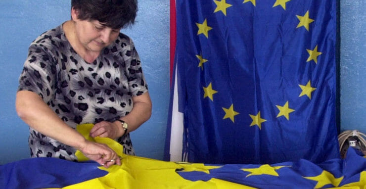 Na snímke Jozefína Gregorová obstriháva nášivky hviezd na zástave Európskej únie
